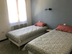 1 dormitorio con 2 camas y ventana en Villa Les Oliviers en Salses-le-Chateau