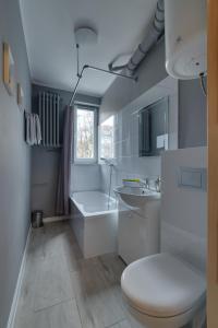 a bathroom with a toilet and a tub and a sink at Apartamenty Old Town Mniszki in Gdańsk