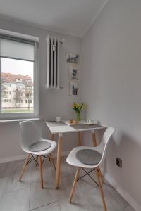 a table and two chairs in a room with a window at Apartamenty Old Town Mniszki in Gdańsk