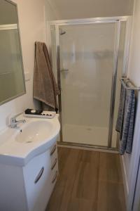 a bathroom with a white sink and a shower at Wallabies Rest in Ben Bullen