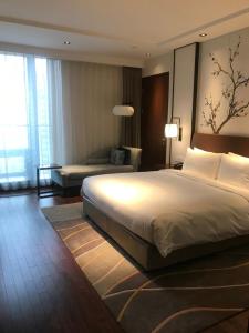 a hotel room with a large bed and a couch at LJZ Supreme Tower 陆家嘴明城酒店 in Shanghai