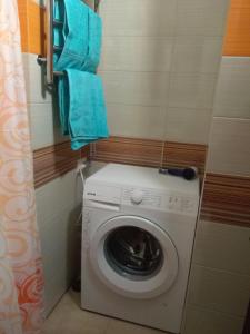a washing machine in a bathroom with blue towels at Apartment on Svobody Square in Kherson