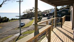 a view from the porch of a house overlooking the ocean at KINGFISHER COTTAGE Beachfront at the Binalong Bay in Binalong Bay