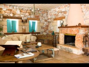 a living room with a stone wall with a fireplace at Pandora in Pyrgos Dirou