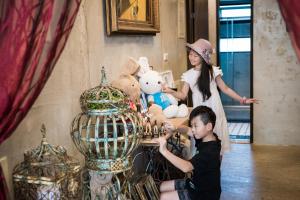 a boy and a girl playing with stuffed animals in a cage at Angel Wings Inn in Hualien City