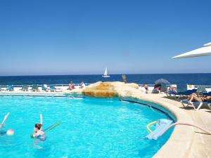 um grupo de pessoas numa piscina perto do oceano em Modern Apartment 20 meters from the Promenade em Sliema