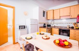 eine Küche mit einem Tisch und einer Obstschale darauf in der Unterkunft Enjoy Aveiro Apartment in Aveiro