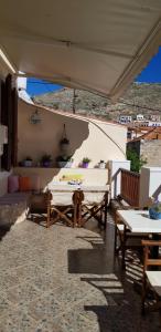 a patio with two tables and chairs under an umbrella at Mika's House in Halki