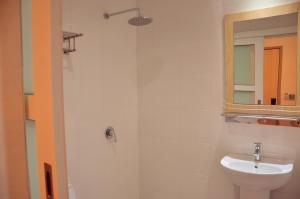 a white bathroom with a sink and a mirror at Hotel Jeti Tg Gemok in Padang Endau