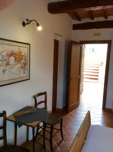 sala de estar con mesa, sillas y puerta en Casa Cernano en Castelnuovo Berardenga