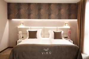 ein Hotelzimmer mit einem großen Bett mit einer weißen Tagesdecke in der Unterkunft VIKO Boutique Apart Hotel in Sofia