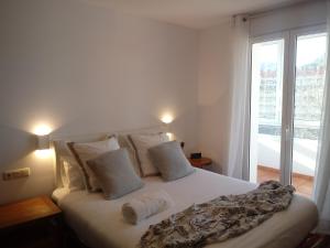 ein Schlafzimmer mit einem Bett mit weißen Laken und einem Fenster in der Unterkunft Apartamento Andoaga in San Sebastián