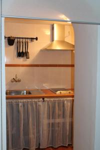 a kitchen with a sink and a stove at Los Balcones de Galaz in Chinchón