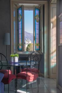 ein Esszimmer mit einem Tisch, Stühlen und Buntglasfenstern in der Unterkunft Casa Stoppani - WelcHome in Cannobio