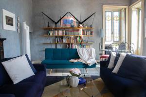 ein Wohnzimmer mit einer blauen Couch und einem Bücherregal in der Unterkunft Casa Stoppani - WelcHome in Cannobio