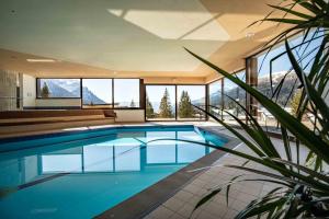a swimming pool in a house with a view of the mountains at Hotel San Martino in San Martino di Castrozza