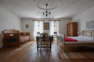 1 dormitorio con 2 camas, mesa y silla en Convivium Transilvania, en Criţ