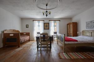 a bedroom with two beds and a table and a chair at Convivium Transilvania in Criţ