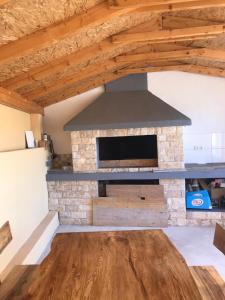 a stone fireplace in a living room with wooden ceilings at Apartmani Mia in Trogir