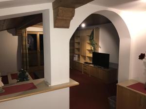 a living room with an archway and a television at Fiechtl Apartments in Stumm