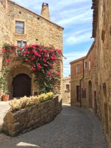 a stone building with pink flowers in an alley at Pals Playa Golf II in Pals