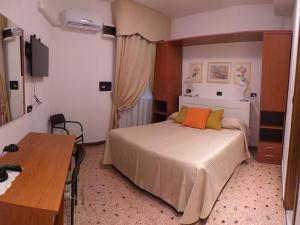 um quarto de hotel com uma cama e uma mesa em Hotel Europa em Albissola Marina