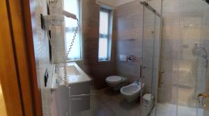 ein Bad mit einer Dusche, einem WC und einem Waschbecken in der Unterkunft Hotel Europa in Albissola Marina
