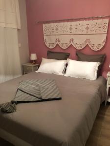 a bedroom with a large bed with a pink wall at 2 Rue de l'Église in Aizecourt-le-Haut