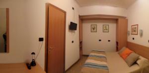 a small bedroom with a bed and a door at Hotel Europa in Albissola Marina