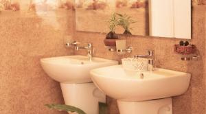 een badkamer met een wastafel, een toilet en een spiegel bij Bohemian Hotel - Negombo in Negombo
