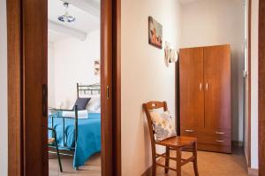 - un couloir avec une chambre dotée d'un lit et d'une chaise dans l'établissement Case Vacanza Torre Canne, à Torre Canne