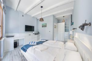 a white room with a bed and a tv at Apartamenty Sun & Snow Błękitna Laguna in Jurata
