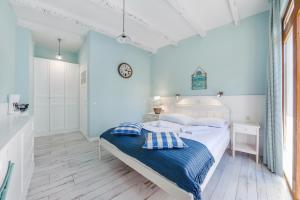 a bedroom with a white bed with a blue blanket at Apartamenty Sun & Snow Błękitna Laguna in Jurata