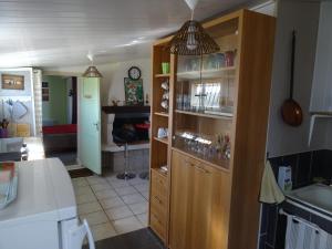 une cuisine avec une grande armoire en bois et des verres dans l'établissement au coeur de la campagne, à Donzac