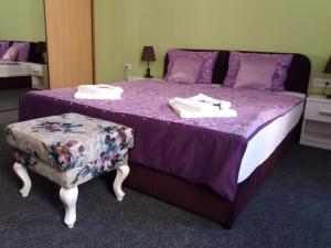 a purple bed with a purple comforter and a chair at App&Rooms "Rime" in Sarajevo