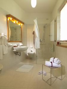 a bathroom with a sink and a toilet and a shower at Hotel Miralago in Bossico