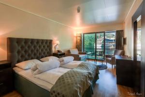 a bedroom with a large bed and a living room at Havila Hotel Geiranger in Geiranger