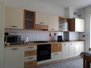 a kitchen with white cabinets and a stove top oven at Via della Chiusa 101 in Sestri Levante