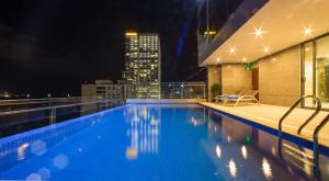 - une piscine sur le toit d'un bâtiment la nuit dans l'établissement DTX Hotel Nha Trang, à Nha Trang