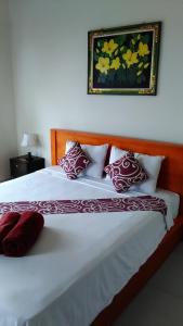 a bed with red and white pillows on it at Gula Juruh Beach Front in Amed