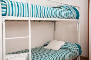 a bunk bed with a blue and white striped sheet at Case Vacanza Torre Canne in Torre Canne