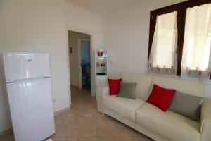 a living room with a white couch and red pillows at Borgo Cenate in Santa Caterina di Nardò