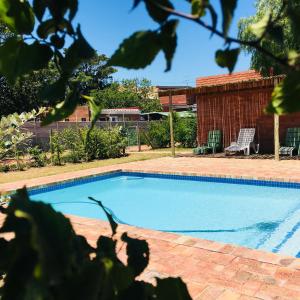 a swimming pool in a yard with two chairs at Addo River-View Lodge in Colchester