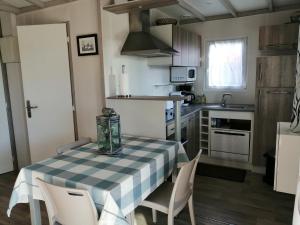 a kitchen with a table and chairs in a kitchen at les Bains de Mer in Grandcamp-Maisy