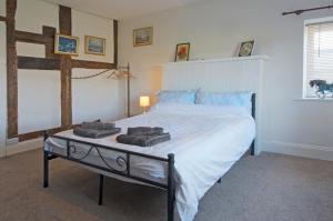 a bedroom with a large bed with towels on it at The Old Farm House in Hereford
