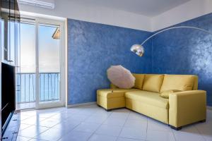 un soggiorno con divano giallo e parete blu di Seaview Cocò Home a Piano di Sorrento