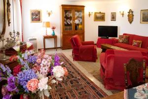 una sala de estar con muebles rojos y flores en una alfombra en Bell'appartamento nel cuore di Venezia en Venecia
