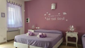 una camera con 2 letti singoli e pareti viola di B&B Margherita a Ostuni