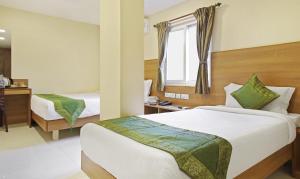 pokój hotelowy z 2 łóżkami i oknem w obiekcie Itsy By Treebo - Jansi Residency w mieście Coimbatore