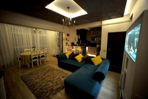 sala de estar con sofá azul y TV en Classic Apartment, en Brasov
